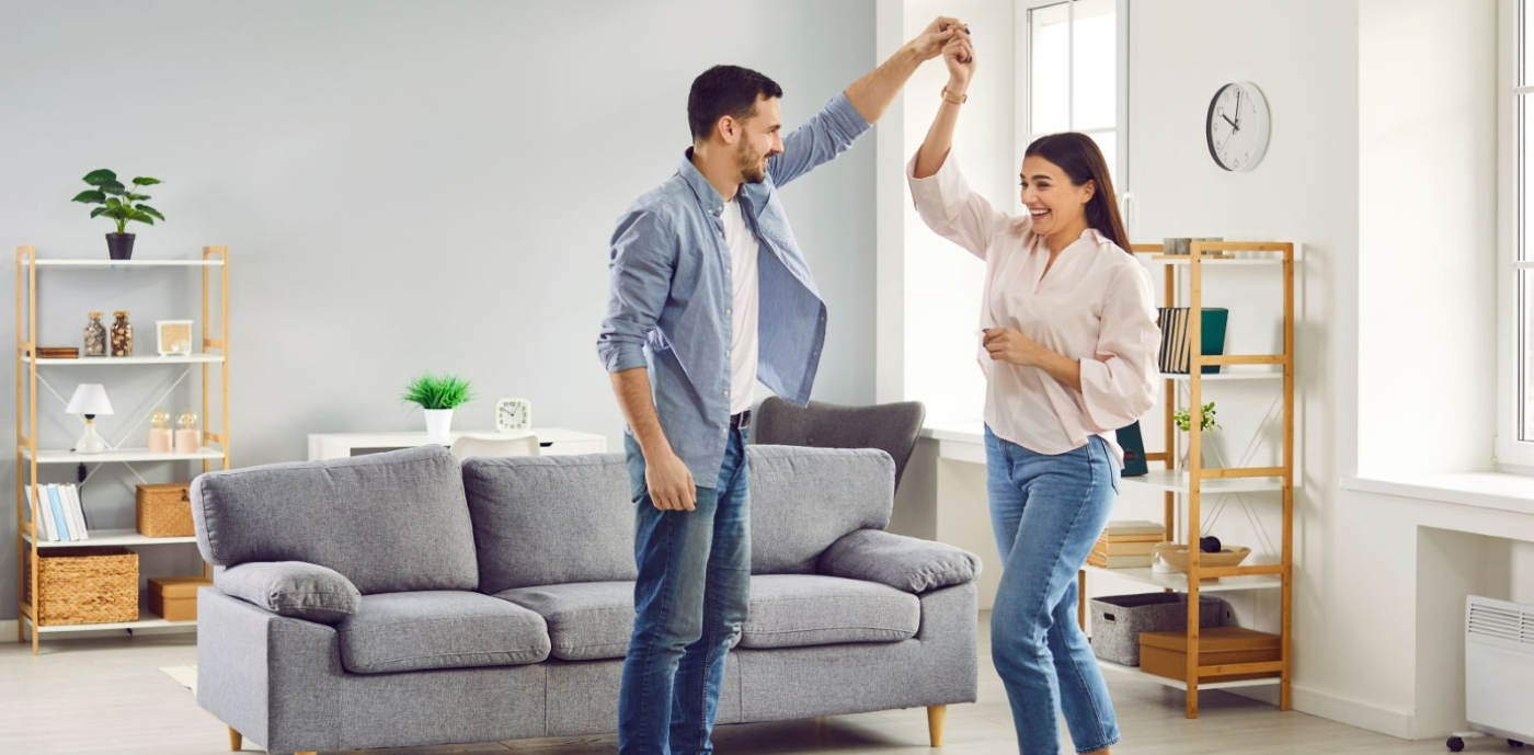 couple dansant dans un salon en souriant